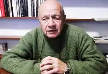 A photograph of İsmail Beşikçi in a green sweater