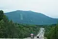 An alpine ski slope is visible on the slopes of the Khekhtsir ridge, seen from the A370 highway, Khabarovsk Krai