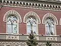 Second floor Gothic windows with elements of rose windows.