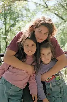 Image of Cohen hugging both her daughters