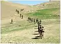 Members of the 8th Commando Kandak and coalition Special Operations Forces patrol though a valley near Nawa Garay village, Kajran district, 2012.