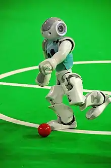 A robot goes for the ball and competes in Robocup.