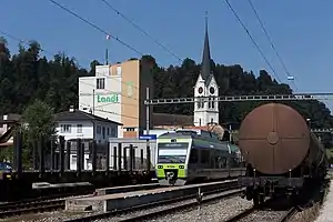 Green-and-blue train in railway yard