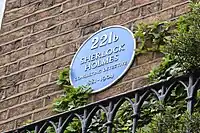 A blue plaque commemorating Sherlock Holmes' fictional residence at 221B Baker Street.