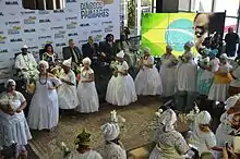 Women in white dresses in a semi-circle