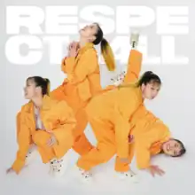 Various copies of Ai are displayed in a photo, all wearing orange jackets and pants with a white shirt underneath and white shoes. The farthest left copy of Ai looks to the side while slightly down on the ground, the middle jumps up in glee, the right bends down while eyeing the viewer, and the far right lays on the ground smiling. The album's title is displayed behind them in bright white lettering