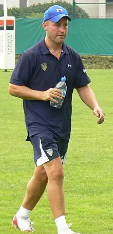 Alex King walking with a plastic water bottle in his right hand during a training session for a rugby match