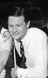 Alex Higgins smiling, holding a cue stick