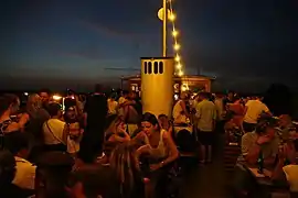 Party guests on the upper deck having a view over nightly Sendling