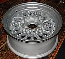 An aluminium alloy wheel designed to recall the crossed spokes of a wire wheel