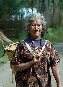 An Apatani woman with a basket going to the field.