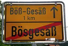 A german city sign of "Bößgesäß", with the reference to Böß-Gesäß, one kilometer away.