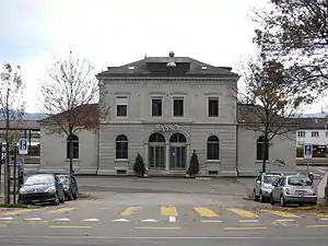 Two-story stone building with hip roof and single-story wings