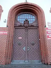 Main door, transom light and coat of arms