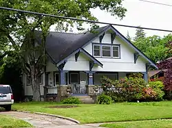 Photograph of a 1½ story house with peaked roof and porch