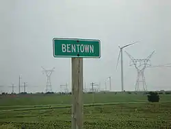 Town sign with turbines in background