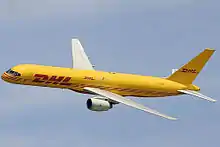 Side view of yellow twin-engine jet in flight