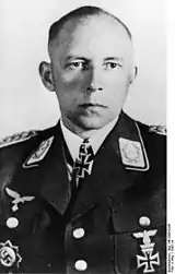 Black-and-white photo of a man wearing military uniform with various military decorations including an Iron Cross at his neck.