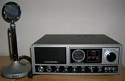 Black-and-gray 1980s-era base station, with tall round desk microphone