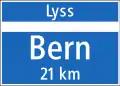 4.28 End of town/village on main road (mentions next village/town above and distance to next major place(s) below the horizontal line)