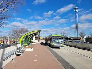 A bus at a bus station with a curved canopy