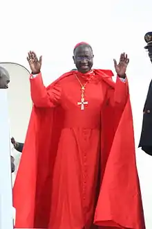 Théodore Adrien Cardinal   Sarr with a ferraiolo, and wearing a red cassock, but not the rest of the choir dress.