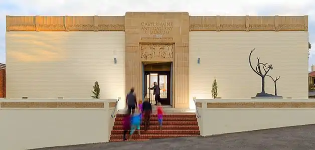 The facade of the Art Museum at dusk with a family walking up the steps