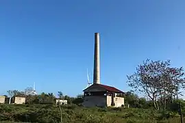 View of the ruins with the modern wind turbines in the background.