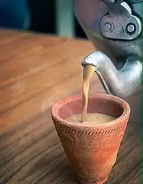 Indian Masala chai served in a red clay tea cup.