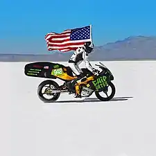 Chip Yates Rides the electric motorcycle at Bonneville carrying an American Flag.