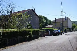 Deux maisons mitoyennes derrière des clôtures.