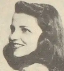 A smiling young white woman with long dark hair