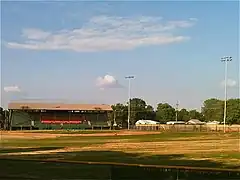 View of a grandstand and baseball field from the furthest point of the outfield