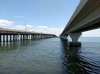 Two bridges crossing a water channel viewed from shore