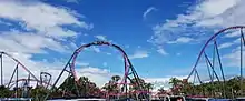 A train twisting through DC Rivals HyperCoaster's non-inverting loop, seen from the car park