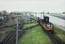 NSWR loco 44216 and another haul the northbound 'Brisbane Limited' across the Corinda line at Yeerongpilly, 1987