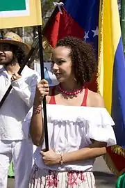 A smiling woman holding a banner