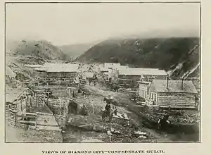 B&W photograph of a street of ramshackle wooden buildings