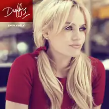 Image of a blonde woman wearing a red T-shirt with her hair in pigtails and with her arms drawn in to her sides. She is staring off-centre to her left and the background appears to have been blurred. In the left corner, the word "Duffy" is written in a red box in signature style. Below is the word "Endlessly" in smaller writing.