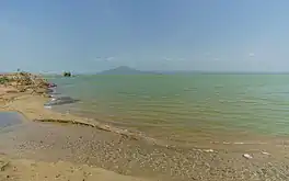 Photograph of the lake with a beach in the foreground