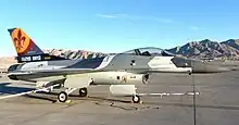 The first F-16C rolls out of the paint shop at Nellis AFB, Nevada, wearing an Aggressor paint scheme and the Wing Flagship tail markings.