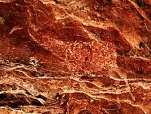 Photograph of a giraffe painted on a rock face