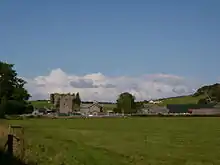 A mixture of old and modern buildings in a field.