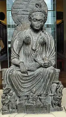 Statue of seated Hārītī with children from Yusufzai in the British Museum, 2nd–3rd centuries CE