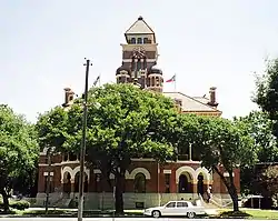 Gonzales County Courthouse. One of the first examples of Gordon's Signature style, featuring corner entrances and an atrium, the Second Empire-style building, built to drawings made in 1890, was placed on the National Register in 1972.