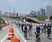 An elevated freeway in a city with bicyclists riding on it