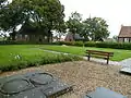 View of the upper side of the mound. In the grass the contours of the former church.