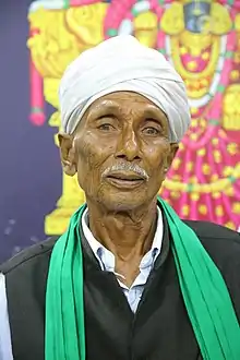 Kanaka Raju wearing traditional clothing and a turban, looking directly at camera