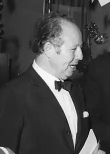 Photograph of a man in a black tie outfit