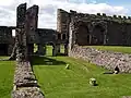 View of refectory site, showing undercroft and lavers at cloister entrance.